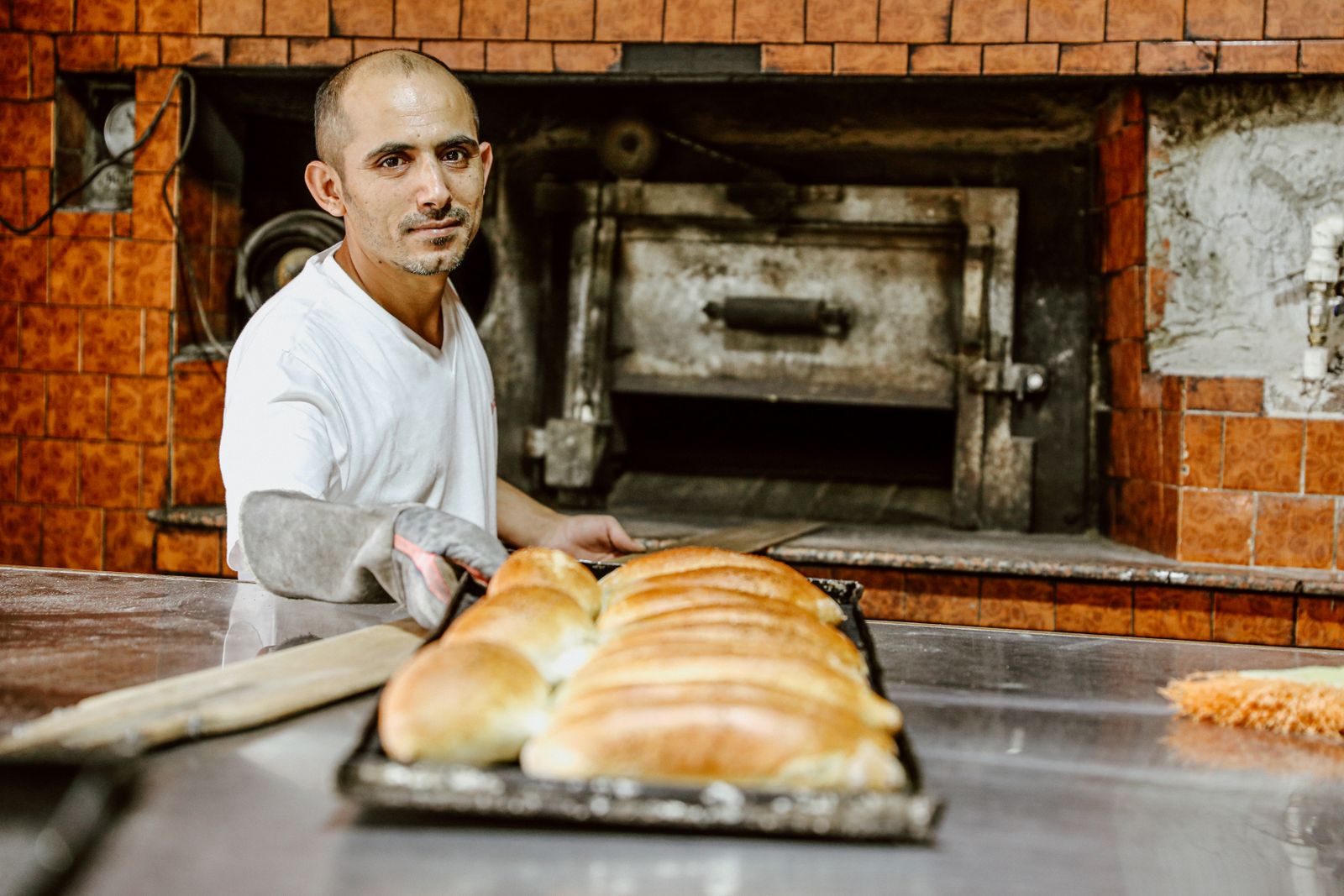 A baker presenting freshly baked bread